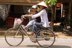 Fahrrad-Expeditionen, Vietnam - Vietnamesin mit Kind auf einem Fahrrad